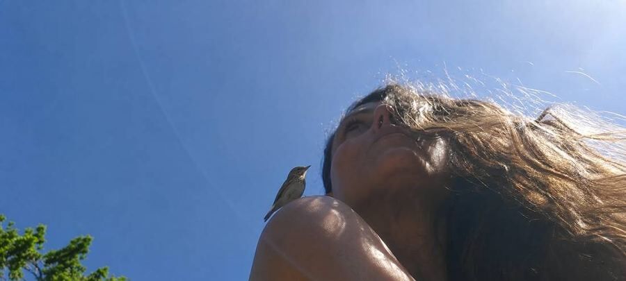A bird landing on Michela's shoulder